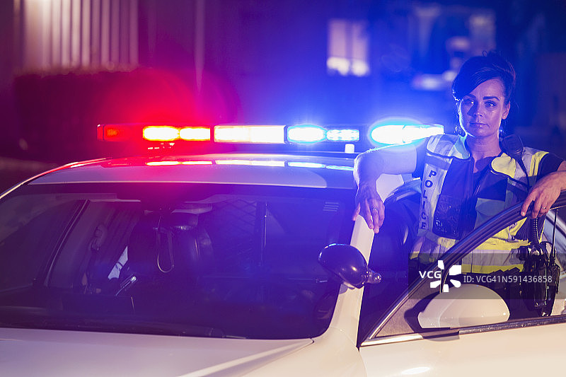 夜晚巡逻车旁的女警官图片素材