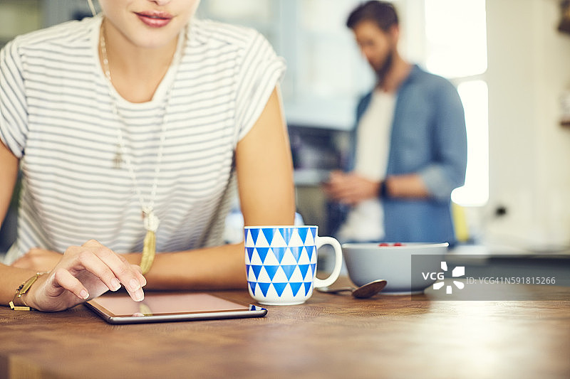 年轻女子触摸平板电脑屏幕的腰部特写图片素材