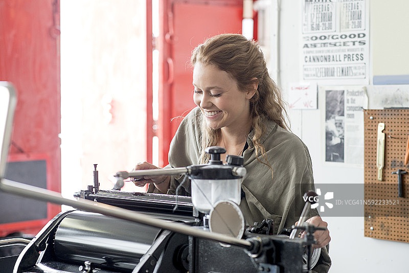 在工作室准备印刷机的女性活字印刷工人图片素材