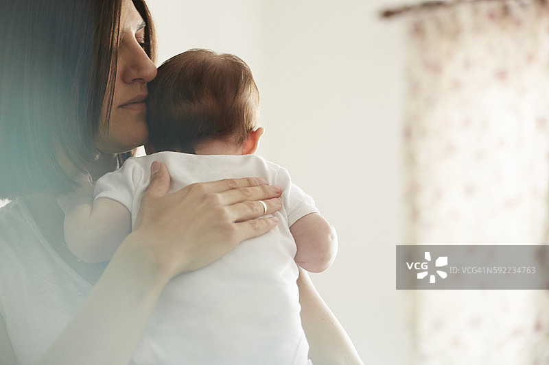 母亲在卧室里抱着婴儿图片素材