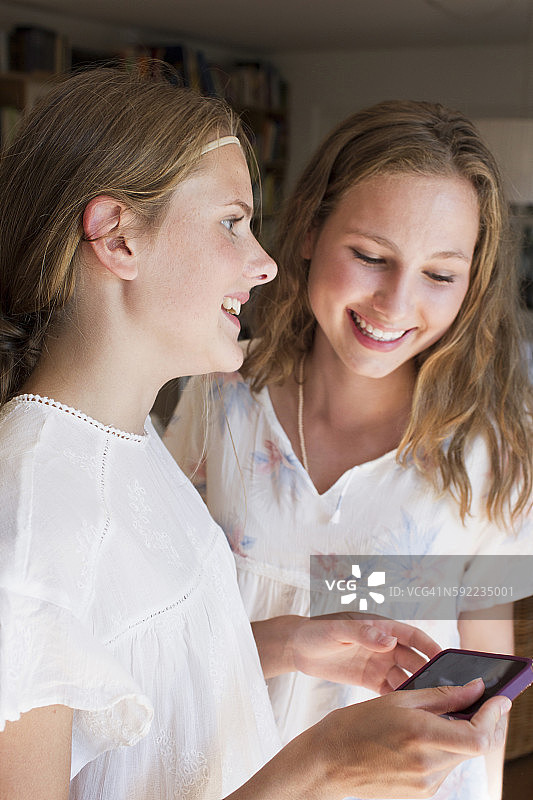 正在阅读手机短信的两个少女图片素材