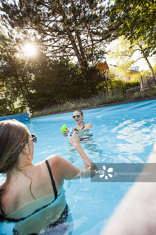 两个少女在游泳池玩水枪图片素材