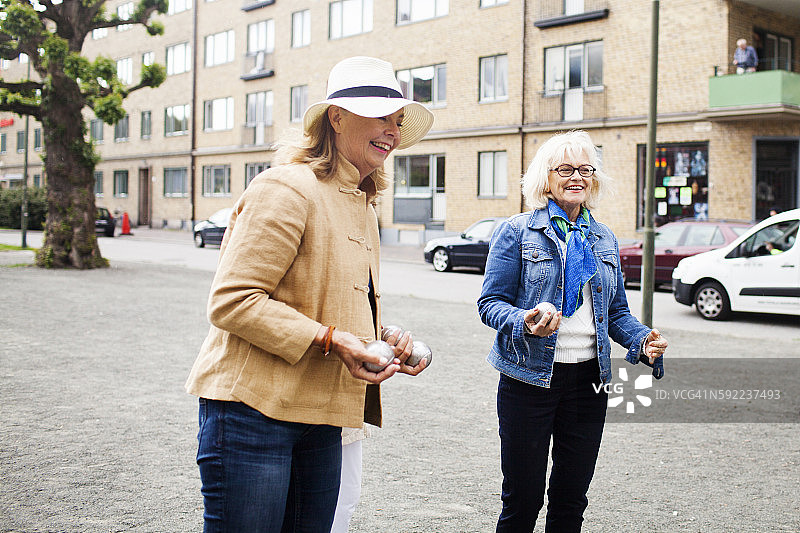 站在街上拿着球的中年妇女图片素材