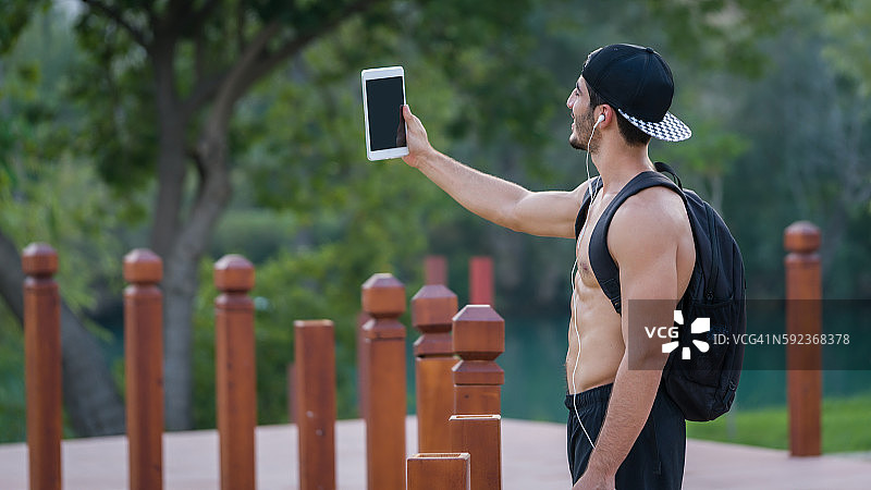 年轻男人用平板电脑自拍图片素材