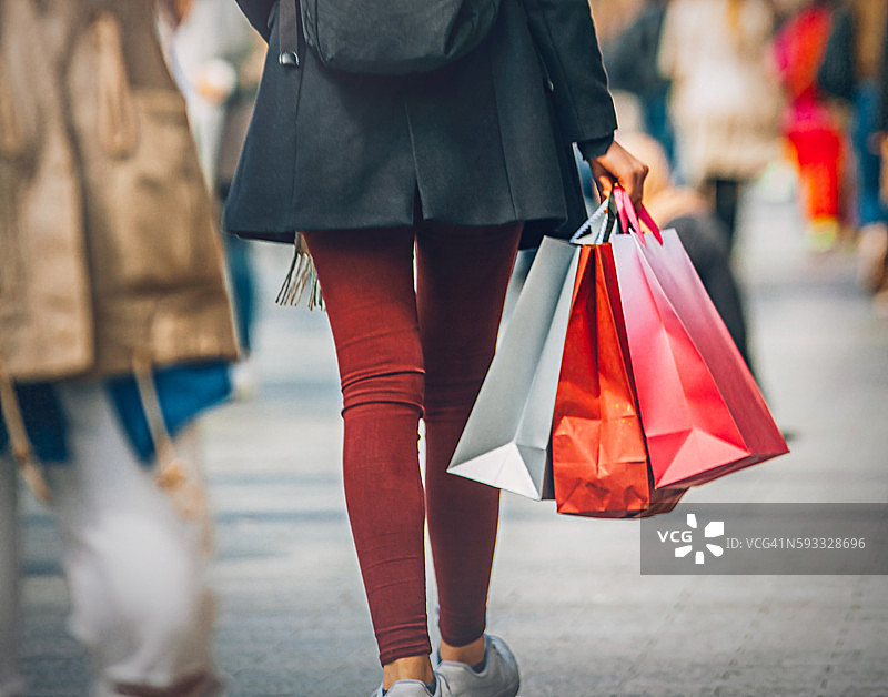 年轻女人在香榭丽舍大街上提着购物袋走路图片素材