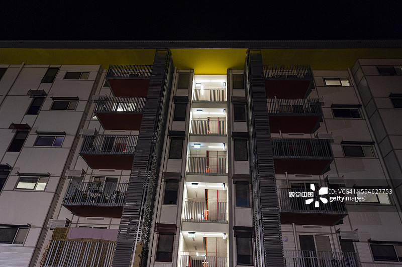 夜晚的内城公寓楼外墙，有窗户和阳台图片素材