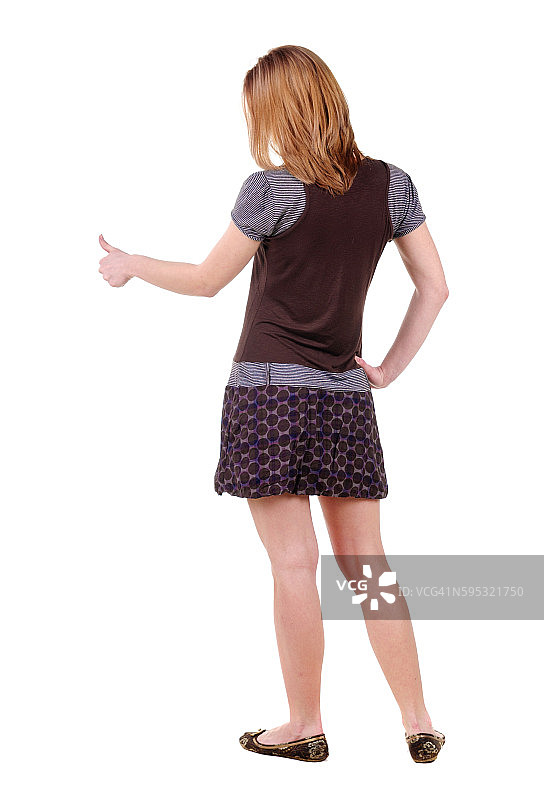 美丽的年轻女人看着墙图片素材