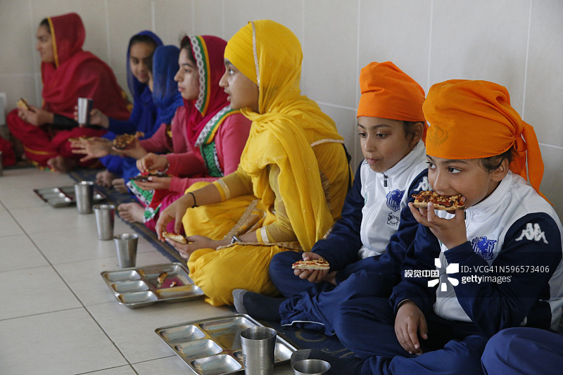 辛格·萨巴锡克教谒师所，法国博比尼。妇女和儿童在langar吃饭。图片素材
