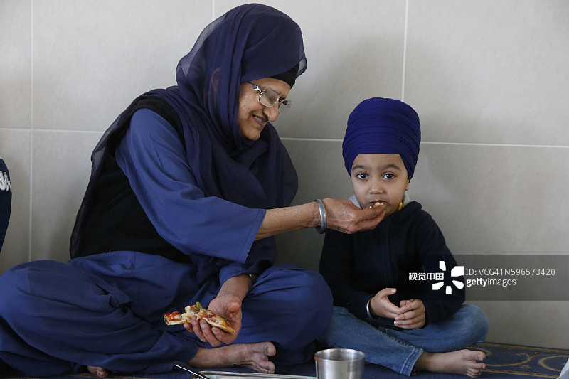 在法国博比尼锡克教谒师所里喂孙子的妇女图片素材