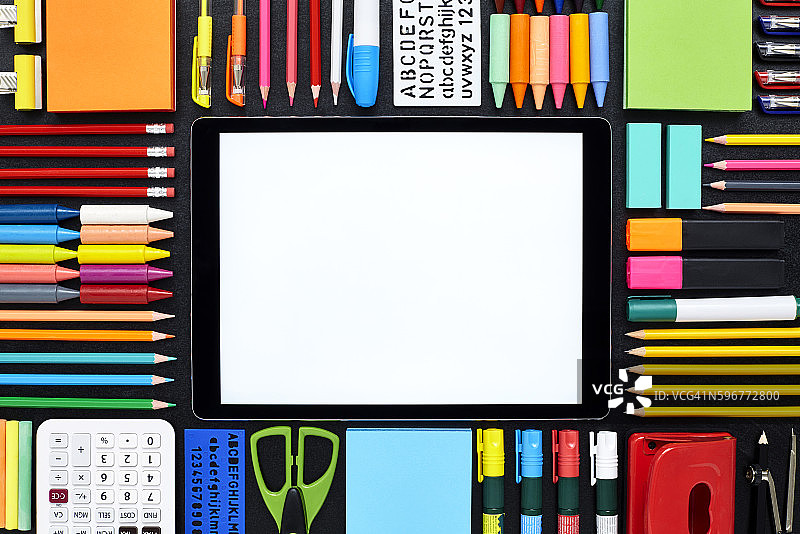 黑板上被学校用品包围的空白数位平板电脑图片素材