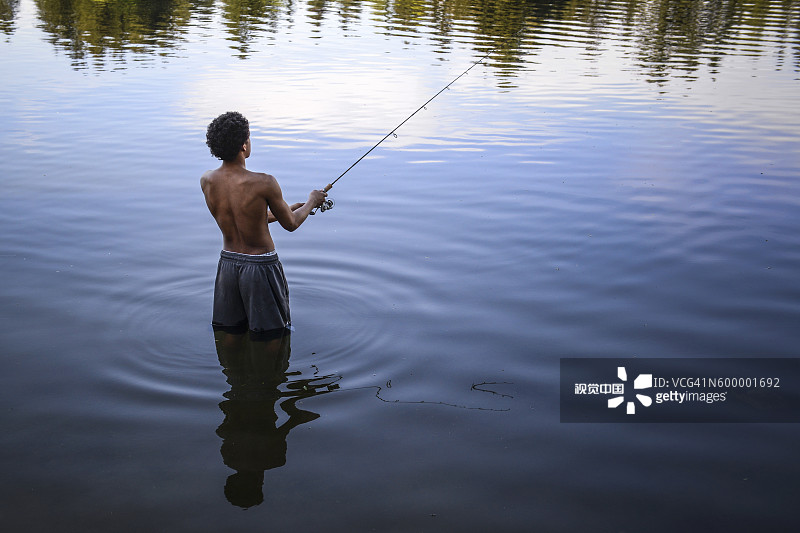 年轻渔民在西雅图苦湖尝试钓鱼图片素材