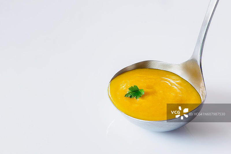 勺子盛胡萝卜姜汤图片素材