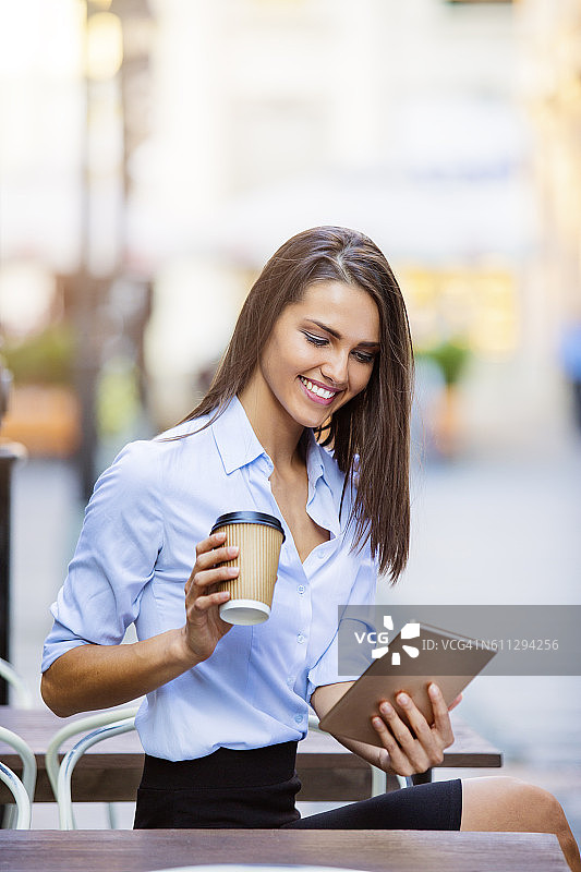 年轻女商人使用平板电脑喝咖啡图片素材