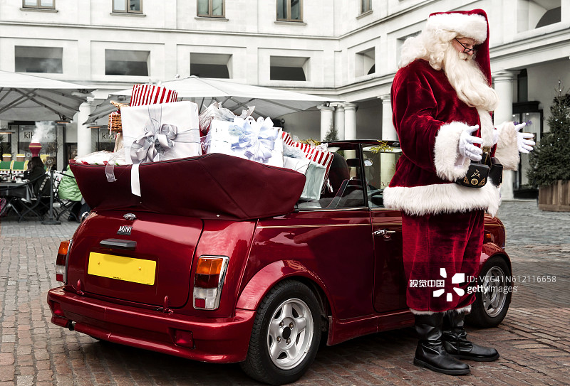 在伦敦科文特花园驾驶迷你敞篷车的圣诞老人图片素材