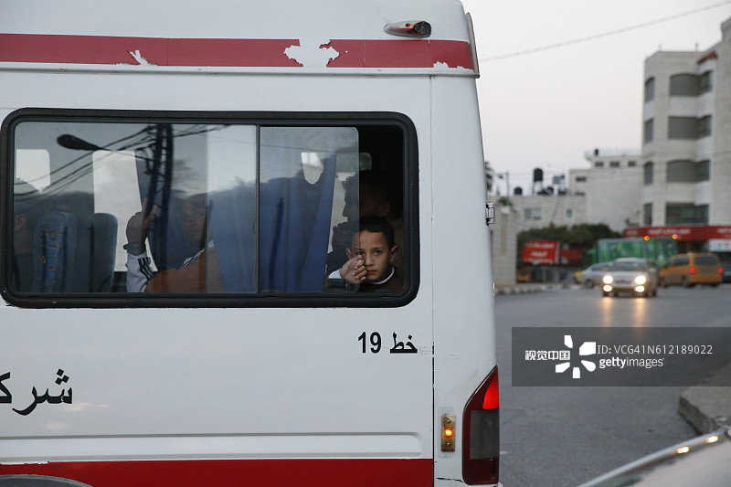 从巴士车窗向外看的巴勒斯坦男孩图片素材