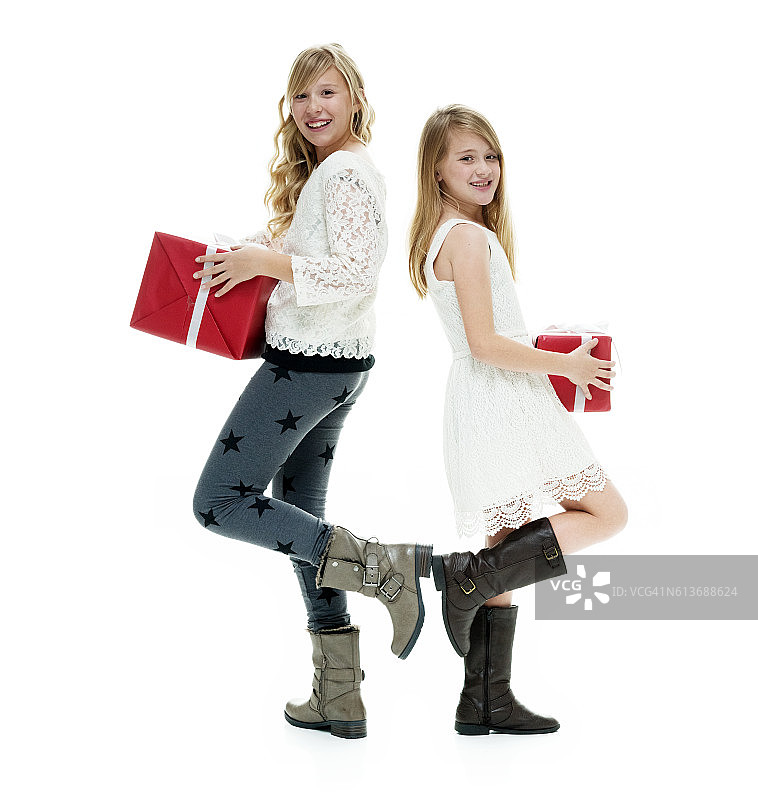 微笑的小姐妹拿着礼品盒图片素材