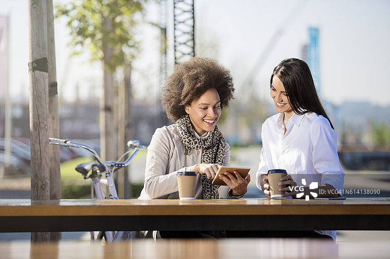 两位漂亮的女人喝着外带咖啡图片素材
