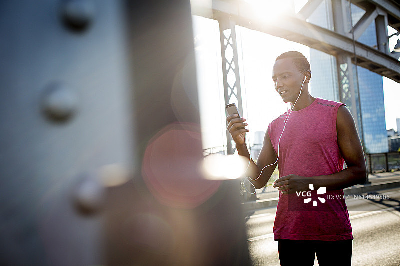 户外运动装跑步者使用智能手机图片素材