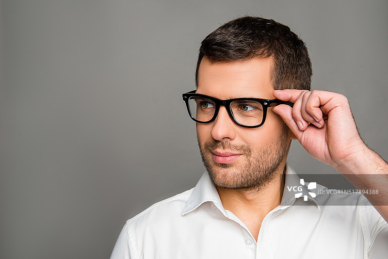 聪明的男人触摸眼镜并向前看图片素材