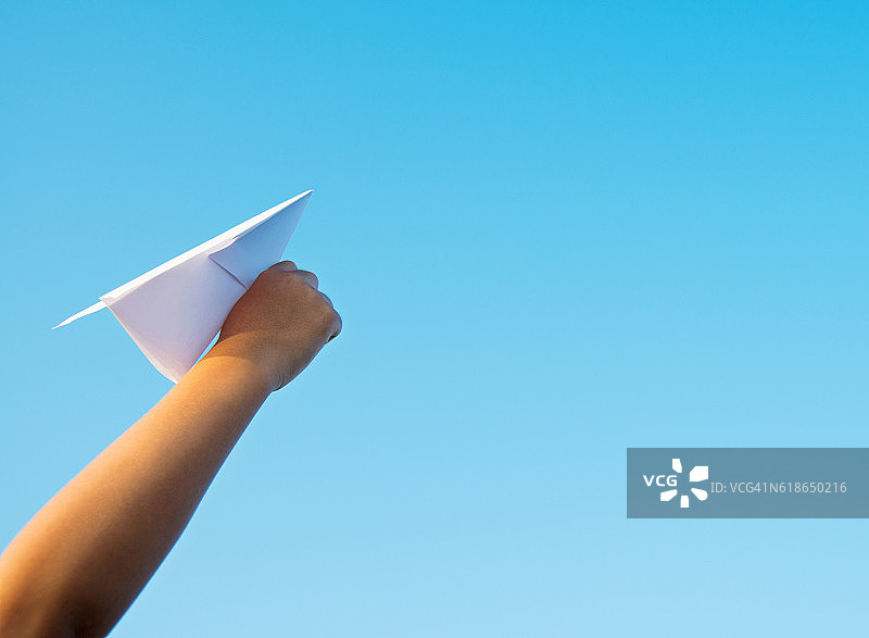 男孩手拿纸飞机看天空图片素材