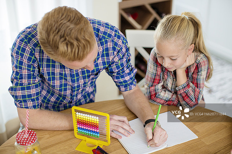 父亲辅导女儿做作业图片素材