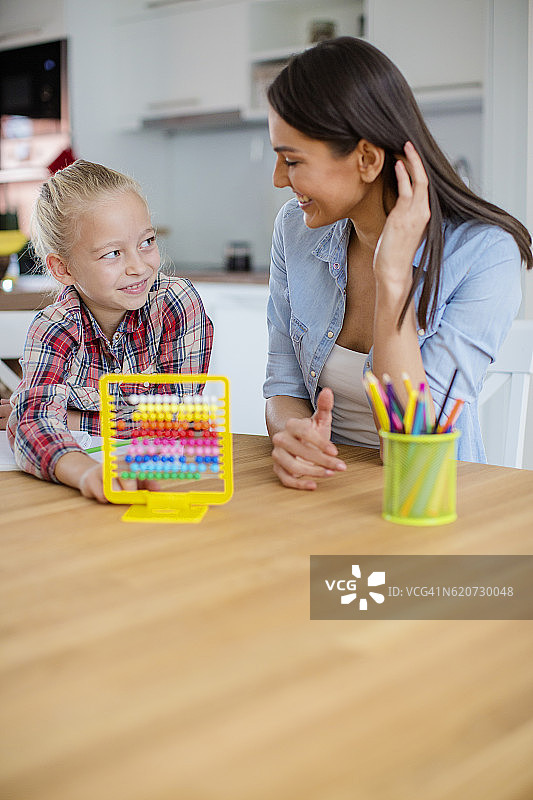 小女孩向妈妈寻求家庭作业的帮助图片素材