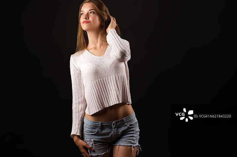 穿着白色毛衣的迷人金发少女图片素材