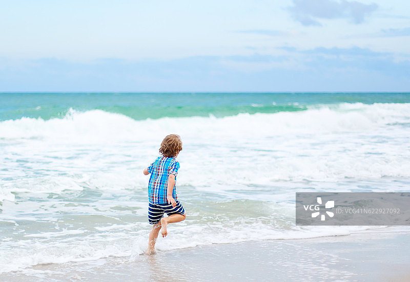 在海滩上奔跑的男孩图片素材