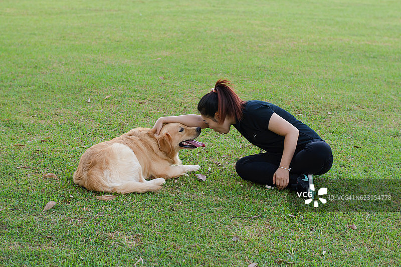 在草地上和狗玩耍的女孩图片素材