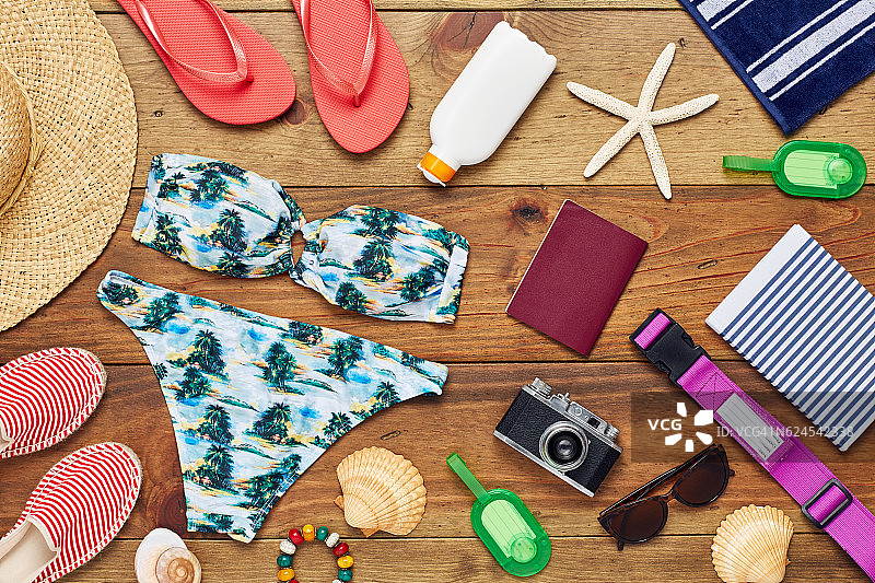 木地板上的旅行和沙滩装备的扁平风格布局图片素材