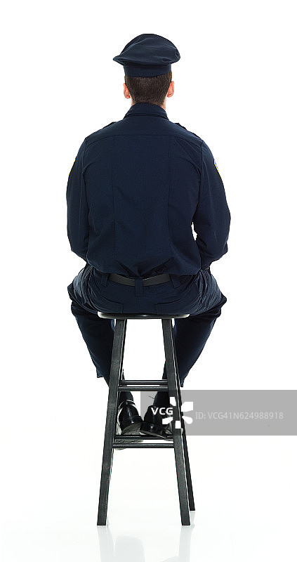 坐在凳子上的警察的背影图片素材