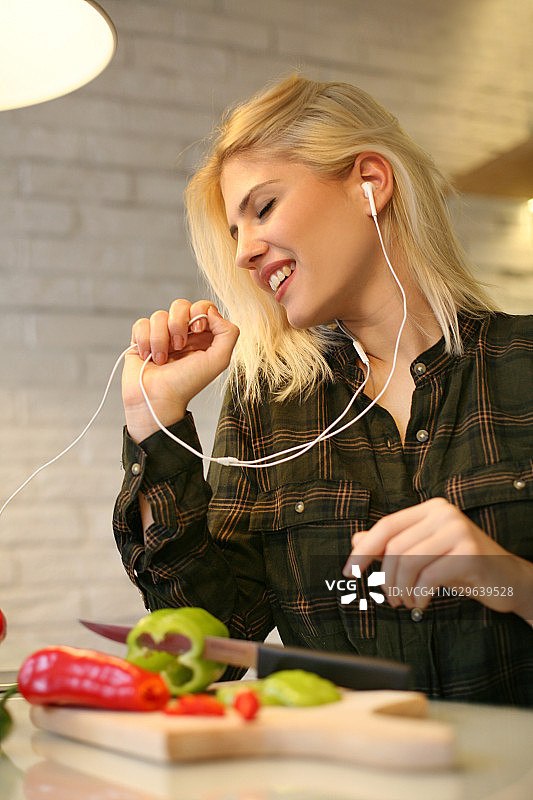 在厨房里听音乐的女人图片素材