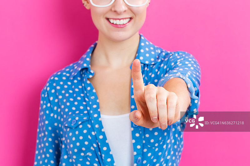 快乐的年轻女人指向某物图片素材