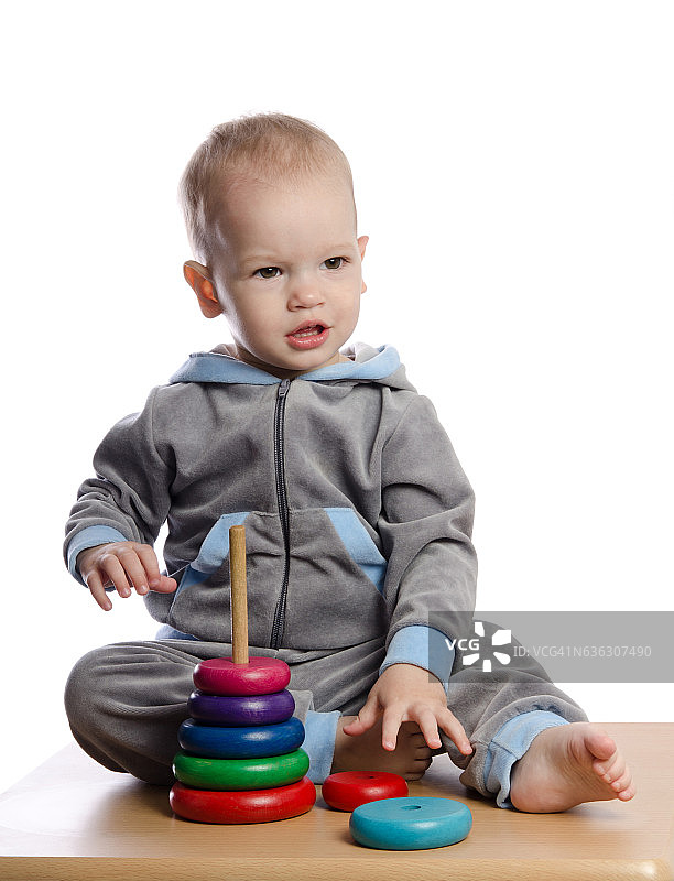 玩彩色金字塔玩具的可爱男孩图片素材