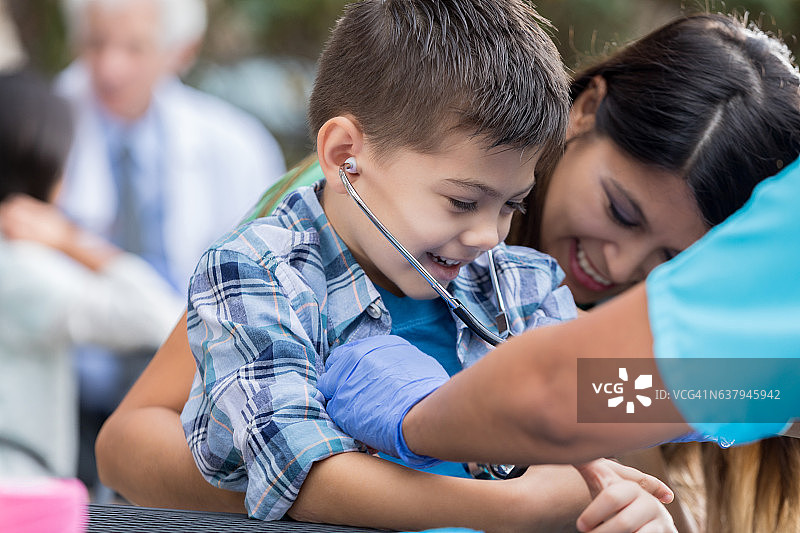 小男孩在免费户外诊所接受检查图片素材