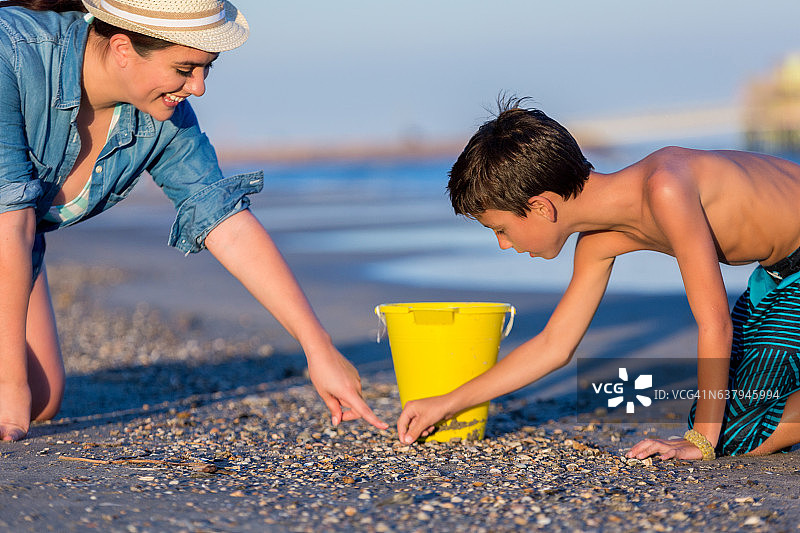 小学生男孩和他的姐姐寻找贝壳图片素材