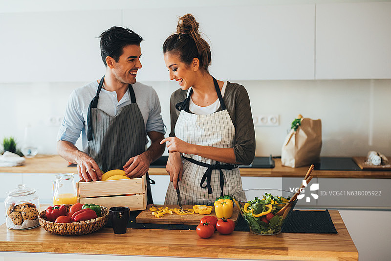 年轻夫妇在厨房做饭图片素材