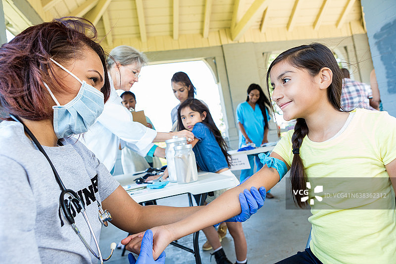 志愿者医生准备为少女抽血图片素材