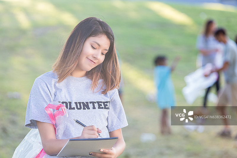 快乐的年轻女人组织志愿者进行社区清理图片素材