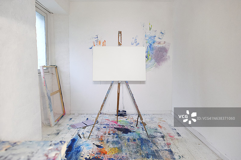 画架上的空白画布和艺术家工作室里的颜料图片素材
