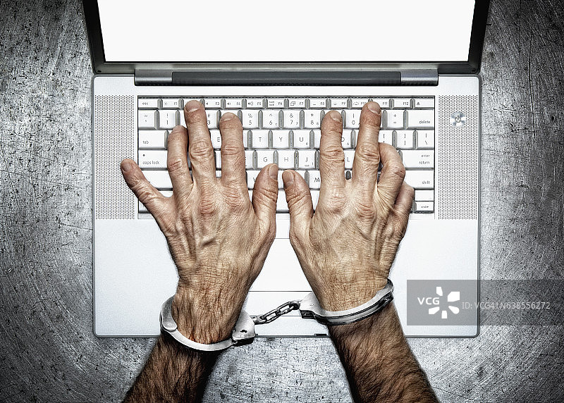 戴手铐和电脑图片素材