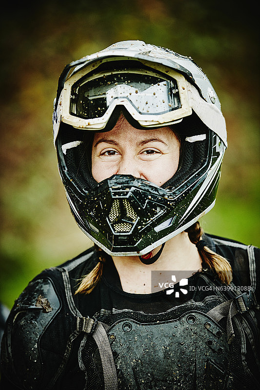 骑完泥地自行车后，面带微笑的女摩托车手肖像照图片素材