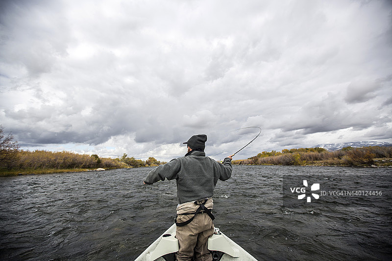男人在河里飞蝇钓鱼图片素材