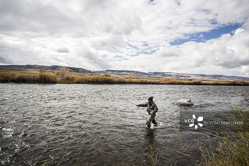 男人在河里飞蝇钓鱼图片素材