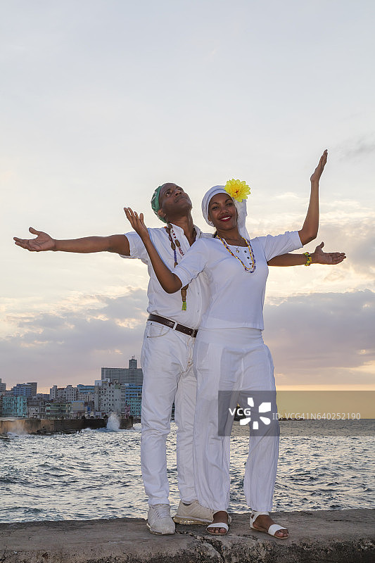 在古巴哈瓦那海滨大道日落时分的年轻古巴夫妇图片素材