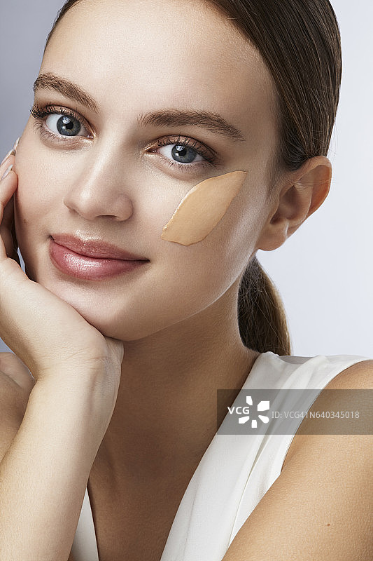 脸上涂着粉底微笑的女人图片素材