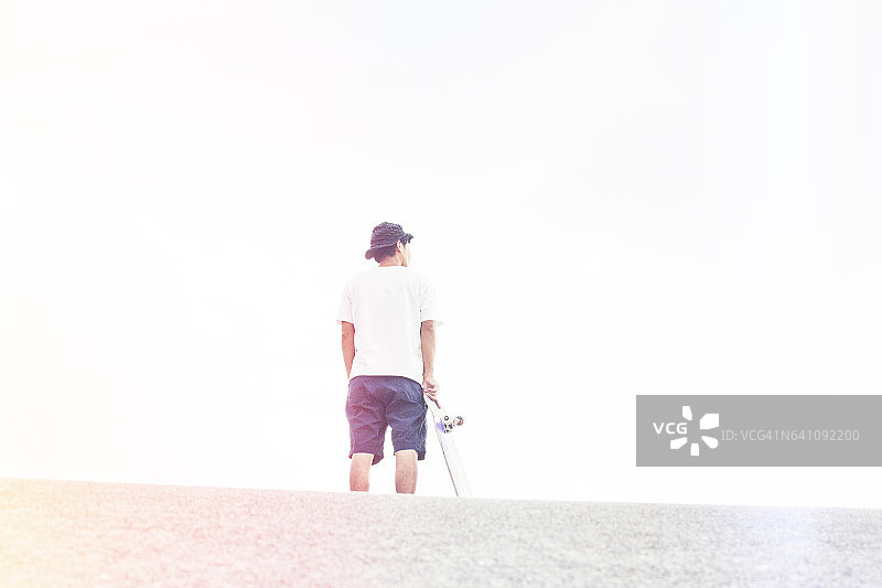 玩滑板的男人凝视远方图片素材