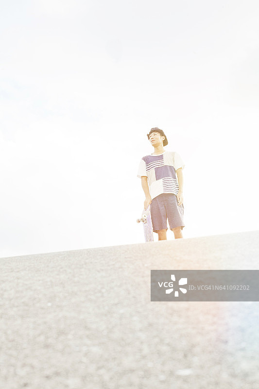 玩滑板的男人凝视远方图片素材