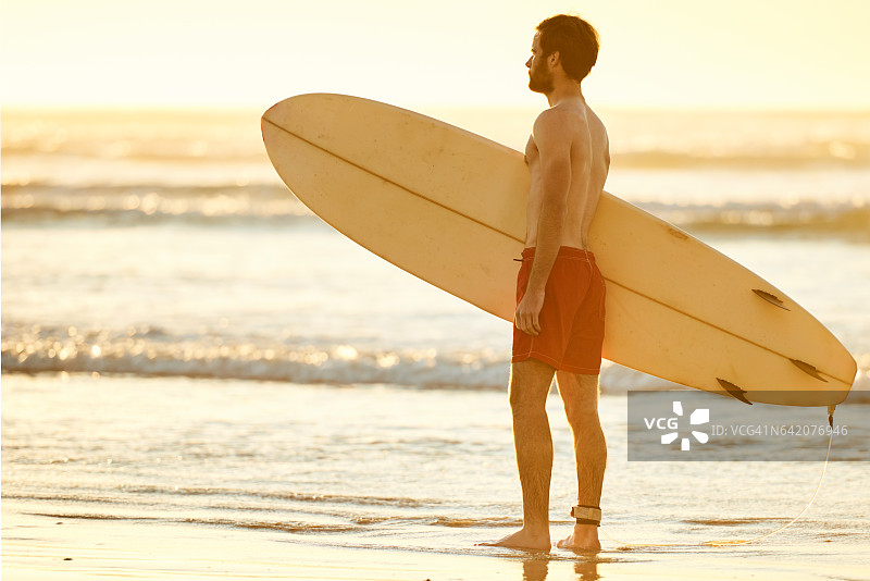 在海滩上拿着冲浪板的男人轮廓照图片素材