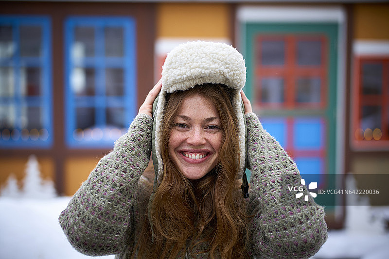 戴着冬帽对着镜头微笑的女人图片素材